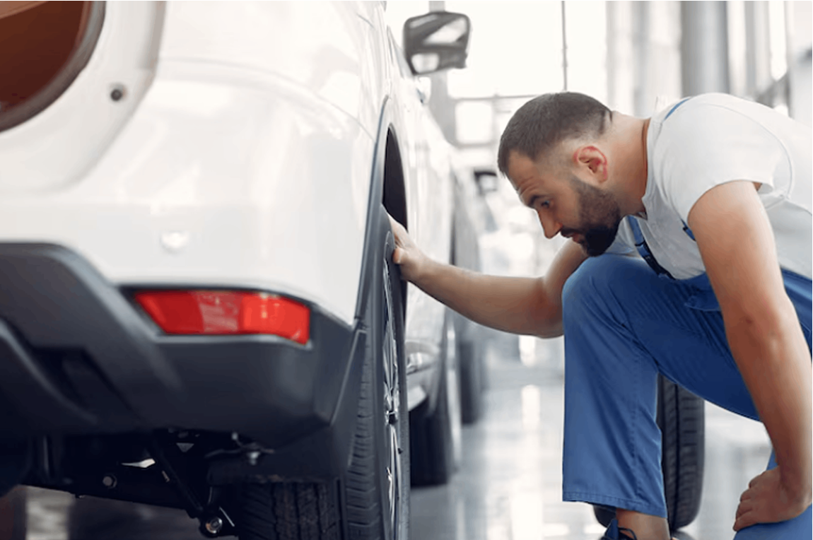 A man inspecting the car after a collision.