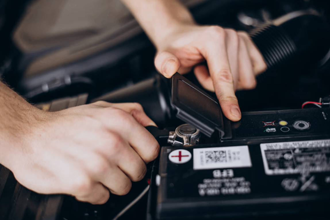 A mechanic changing the car battery.